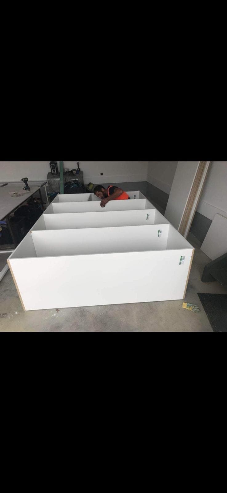 Renovation photo: white bathroom vanity cabinets ready for install