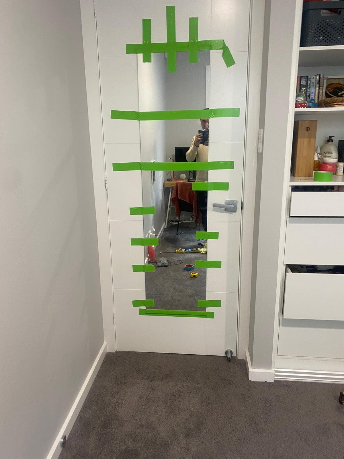 Renovation photo: bathroom mirror framed with green painter tape
