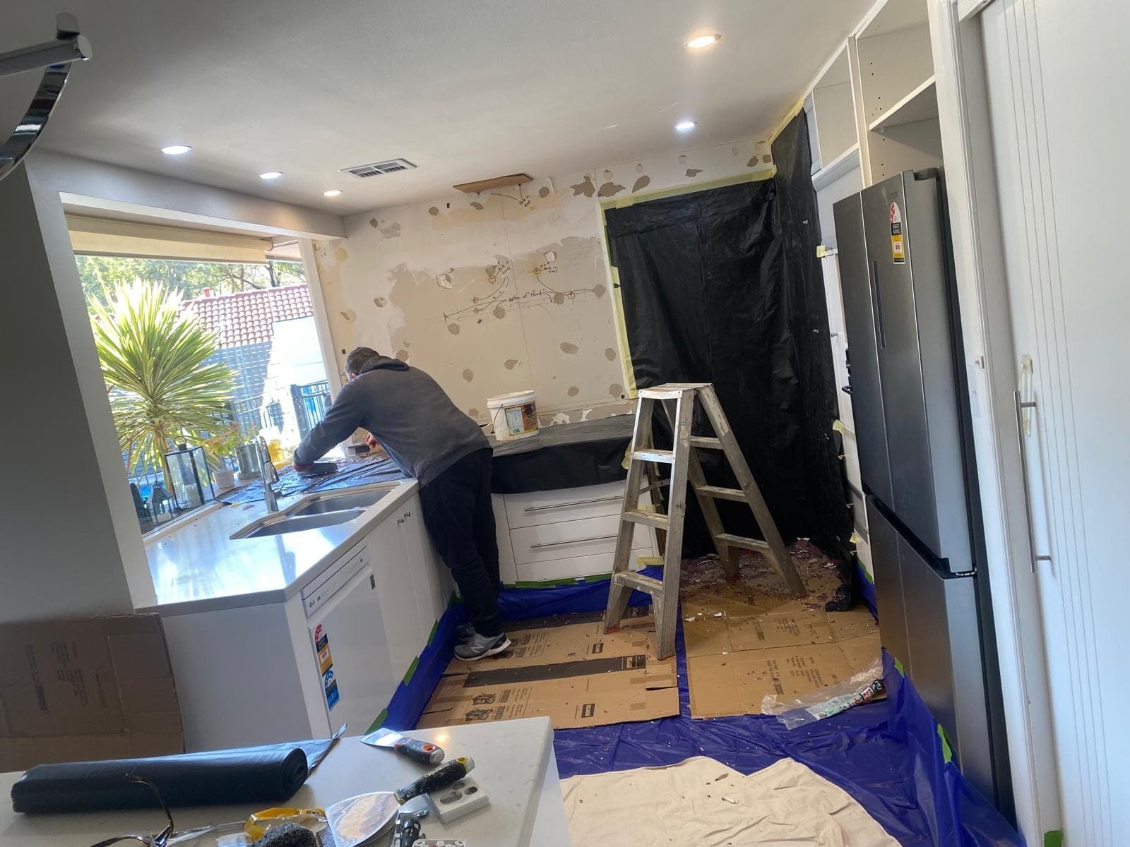 Renovation photo: kitchen renovation with worker at counter